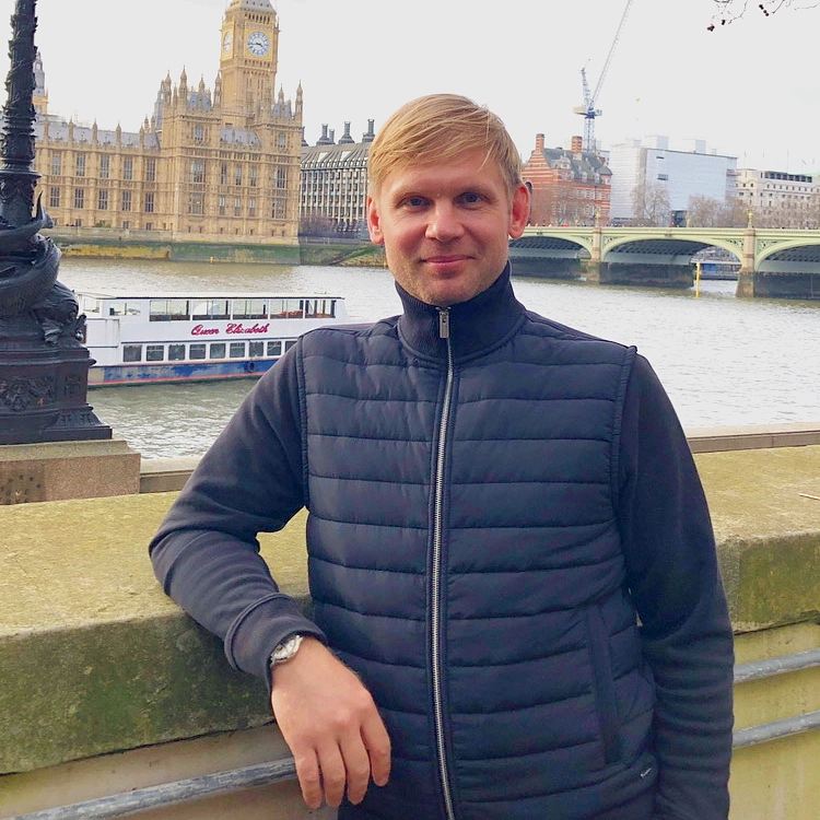 Ivan Zharikov, founder of LDN Tour, by the River Thames with Big Ben and the Houses of Parliament in London.