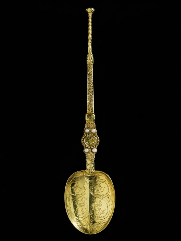Close-up image of the Coronation Spoon from the Crown Jewels collection, shown vertically against a dark background.